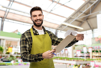 Image showing male gardener with clipboard at flower shop