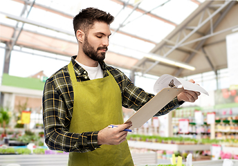 Image showing male gardener with clipboard at flower shop