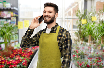 Image showing male gardener calling on smartphone at flower shop