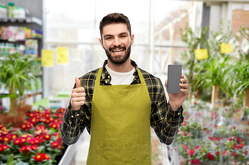 Image showing seller with phone shows thumbs up at flower shop