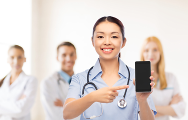 Image showing happy asian female doctor or nurse with smartphone