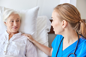 Image showing doctor or nurse visiting senior woman at hospital