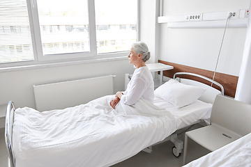 Image showing lonely senior woman sitting in bed at hospital