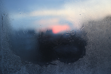 Image showing Melting ice patterns, water drops and sunlight on glass