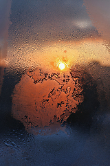 Image showing Ice patterns, water drops and sunlight on a winter window glasss