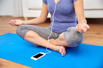 Image showing woman listening to music and meditating at tome