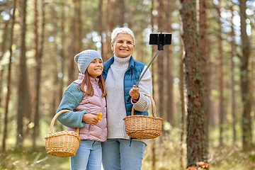 Image showing grandma with granddaughter taking selfie in forest