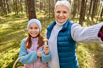 Image showing grandma with granddaughter taking selfie in forest