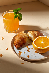 Image showing glass of orange juice and croissant on plate