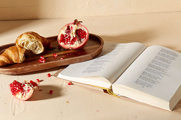 Image showing book, croissant, pomegranate and honey on tray