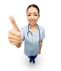 Image showing smiling asian female doctor showing thumbs up