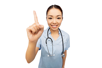 Image showing happy asian female doctor pointing finger up