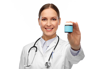 Image showing smiling female doctor holding jar of medicine