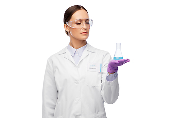 Image showing female scientist in goggles with chemical in flask