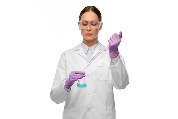 Image showing female scientist in goggles with chemical in flask