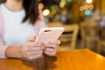 Image showing Woman sending text message on mobile phone