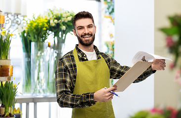 Image showing male gardener with clipboard at flower shop