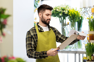 Image showing male gardener with clipboard at flower shop