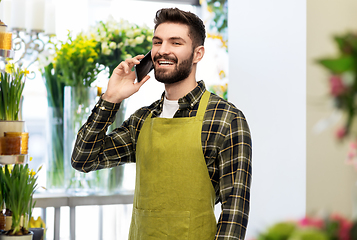 Image showing male seller calling on smartphone at flower shop