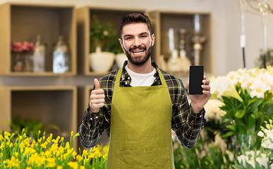 Image showing seller with phone shows thumbs up at flower shop