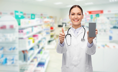 Image showing doctor with smartphone shows thumbs up at pharmacy