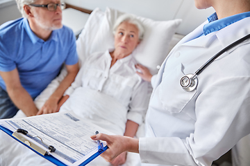 Image showing old couple and doctor with clipboard at hospital