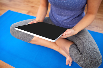 Image showing woman with tablet pc computer doing yoga at home