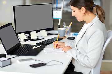 Image showing businesswoman with notebook and laptop at office