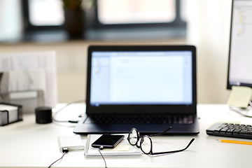 Image showing laptop, smartphone and notebook on table at office