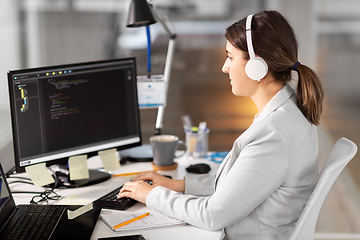 Image showing programmer in headphones with computer at office