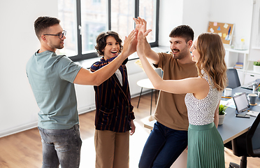 Image showing happy business team making high five at office