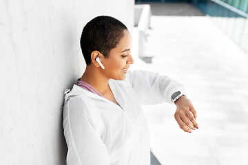 Image showing african woman with earphones and smart watch