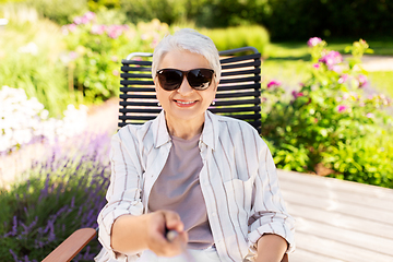 Image showing happy senior woman taking selfie at summer garden