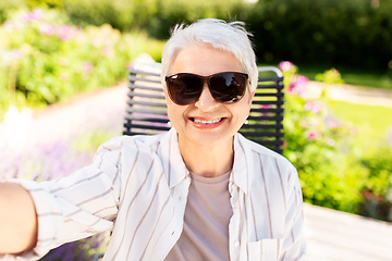 Image showing happy senior woman taking selfie at summer garden