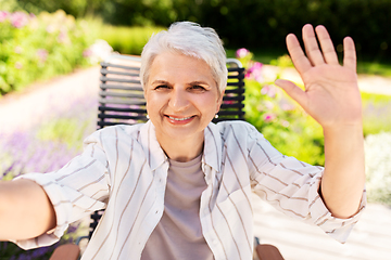 Image showing happy senior woman taking selfie at summer garden