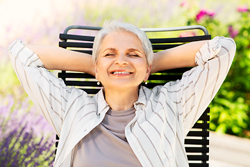 Image showing happy senior woman resting at summer garden