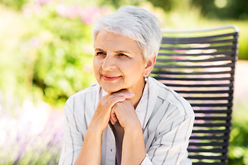 Image showing happy senior woman resting at summer garden