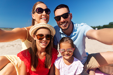 Image showing happy family in sunglasses taking selfie on beach