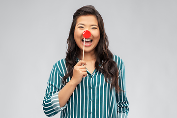 Image showing happy asian woman with red clown nose