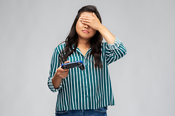 Image showing upset asian woman playing video game with gamepad