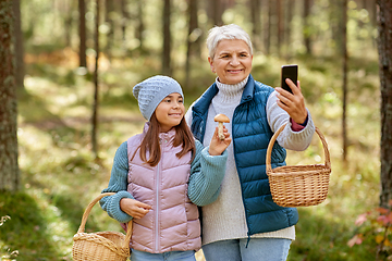 Image showing grandma with granddaughter taking selfie in forest