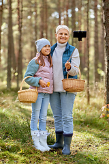 Image showing grandma with granddaughter taking selfie in forest