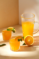 Image showing glasses with orange juice and peppermint on table