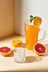 Image showing orange juice, grapefruit and ice in glass on table