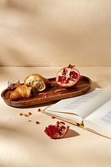 Image showing book, croissant, pomegranate and honey on tray