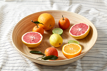 Image showing close up of citrus fruits on wooden plate