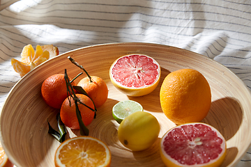 Image showing close up of citrus fruits on wooden plate