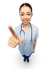 Image showing happy asian female doctor pointing to camera