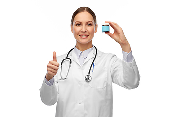 Image showing smiling female doctor holding jar of medicine