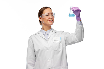 Image showing female scientist in goggles with chemical in flask